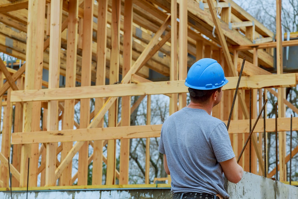 Builders on New home construction site with contractor in foreground