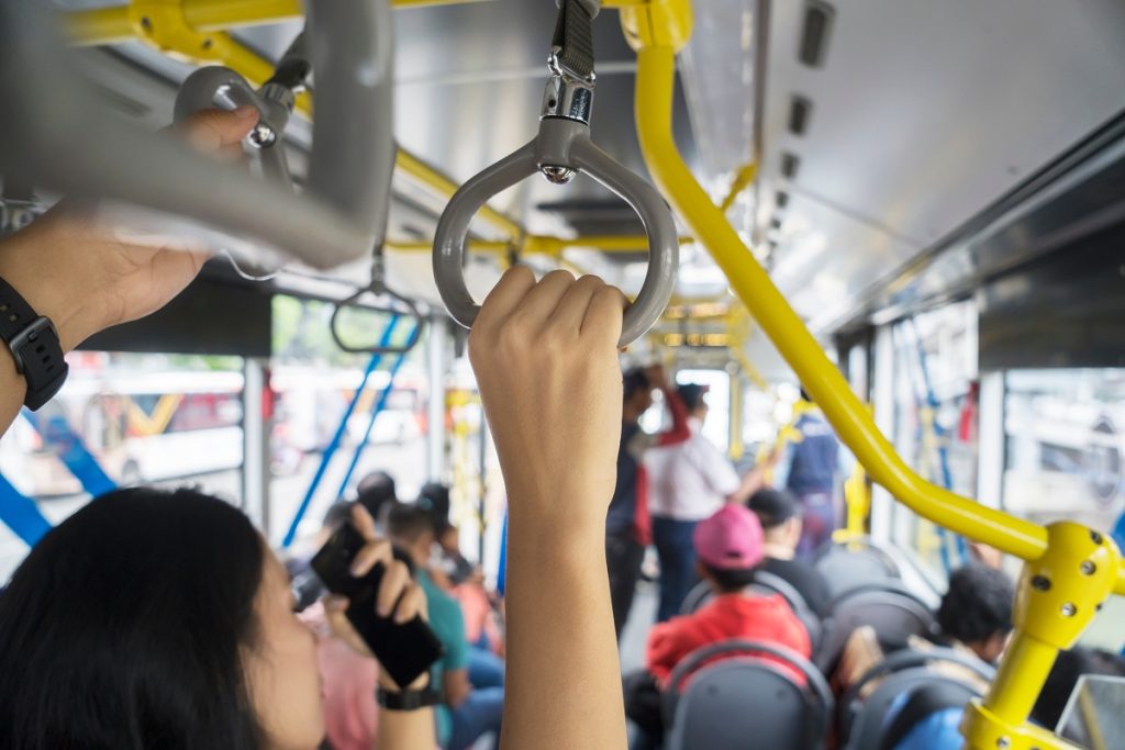 Passengers hold handle on the Transjakarta bus