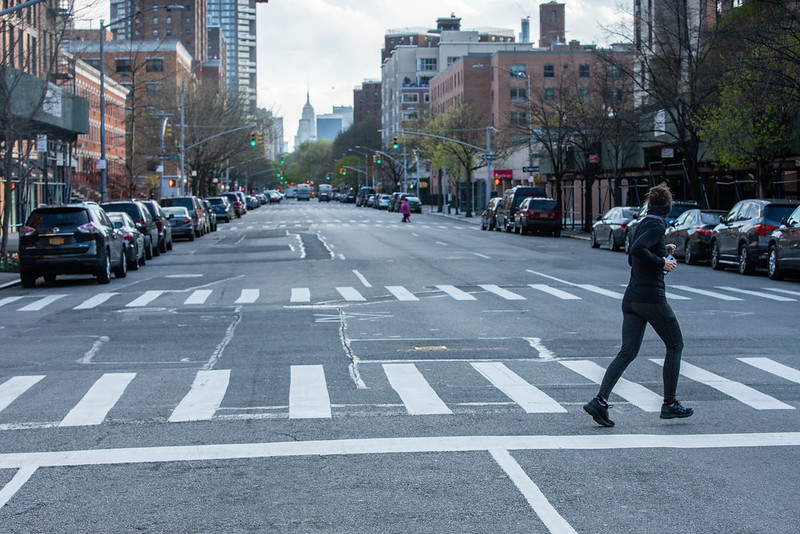 A jogger crossing an empty Manhattan Street.