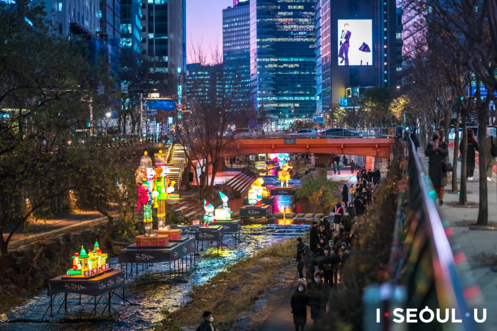 Cheonggyecheon Stream during a celebration with colorful floats on the water. 