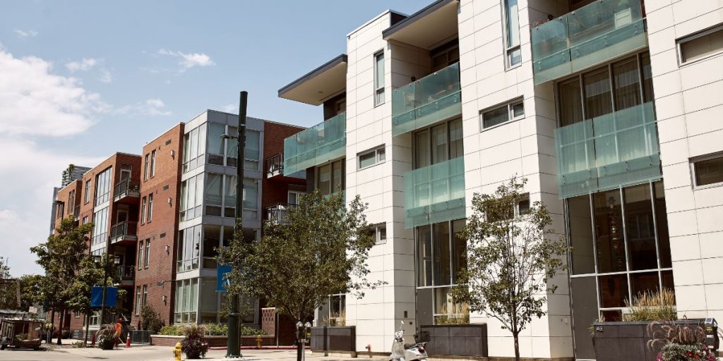Rendering of a development that would be supported by the Transit-Oriented Communities act. There are multi-family buildings next to a light rail line.