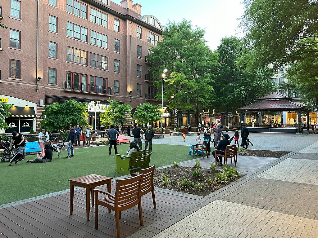 Rockville Town Square with many people walking in the green space.