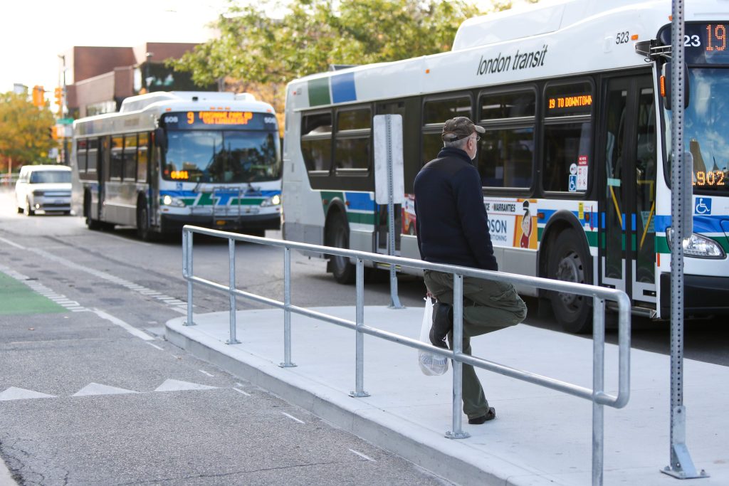 A man waiting for a London Transit bus.