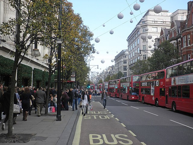 Oxford Street, London, UK with many pedestrians walking on the limited sidewalk space.
