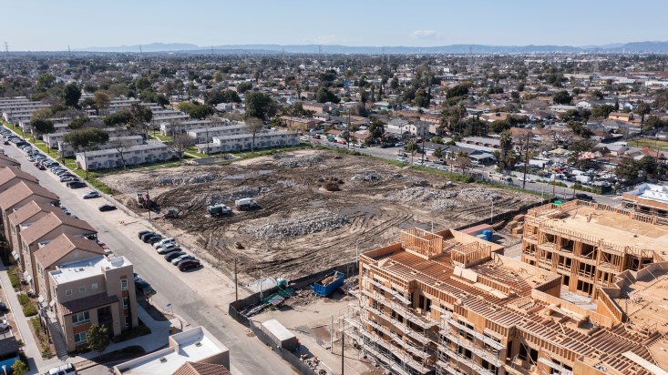 A multi-family housing development under construction in California and and other site being prepared for development.