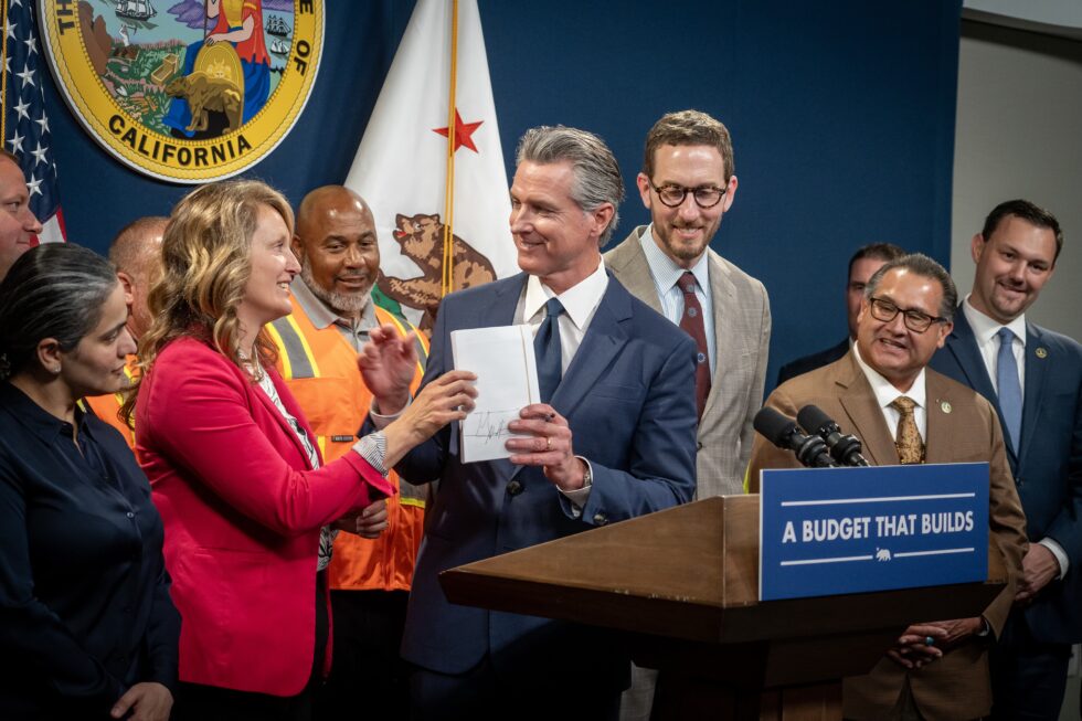 Governor Gavin Newsom signing AB 130 and SB 131 into law.