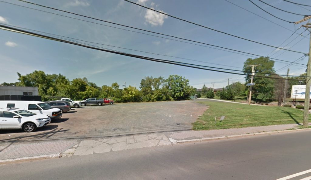 An empty, unpaved lot with some cars