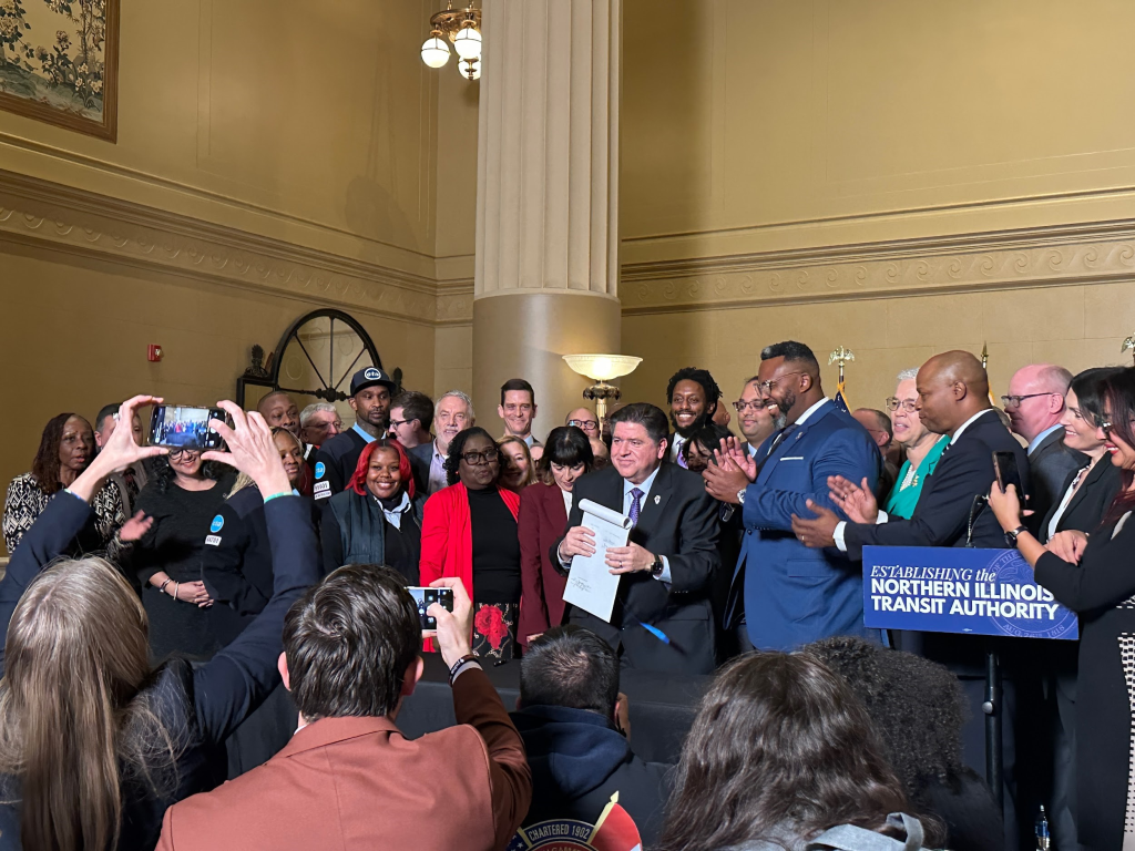 Governor Pritzker and state officials last year signing SB 2111.