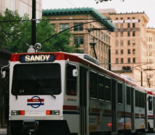 UTA Light Rail train. The train is surrounded by dense apartment buildings in Salt Lake City.