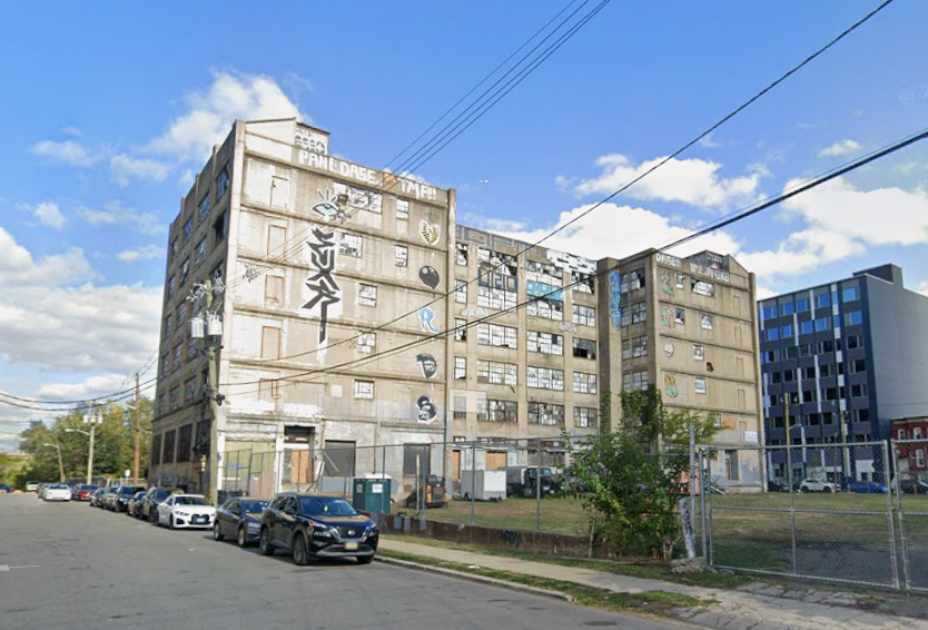 125 Monitor Street in Jersey City, located near the Liberty State Park HBLR Station. It is a vacant building with boarded windows and graffiti