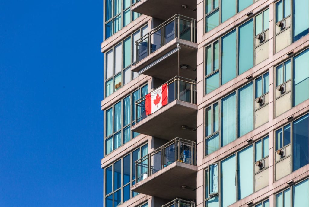Apartment building with a Canadian flag hanging from a balcony